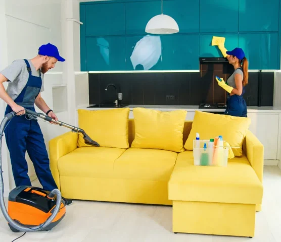 young-man-with-vacuum-cleaner-washing-with-vapor-yellow-sofa-beautiful-woman-wipes-cuisine-furniture-1